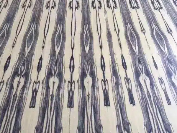 Symmetrically patterned wood veneer with dark streaks on a light background
